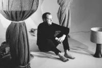 Jeroen De Ruddere, high-end Belgian Designer in his studio, sitting between a bronze lamp and other packaged lamps. This campaign image for Milan Design Week was shot by Alexander D'Hiet.